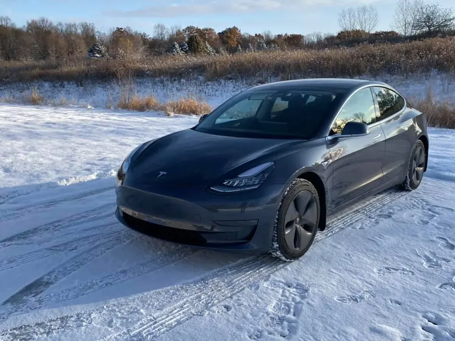 Gray Tesla Model 3 parked in snow