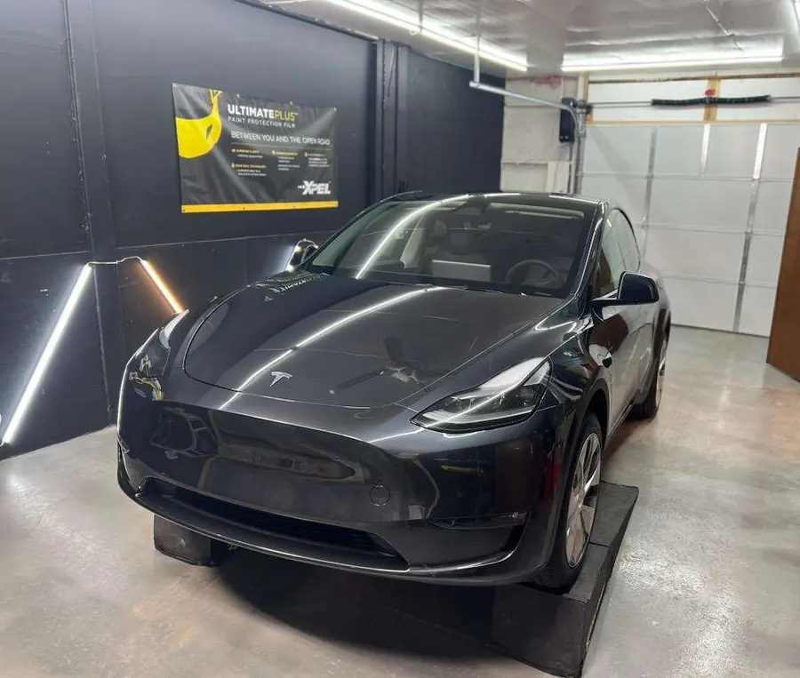 Black Tesla Model Y in the install bay after paint protection film